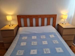 um quarto com uma cama com 2 mesas de cabeceira e 2 candeeiros em Ballintoy house with great sea views em Ballintoy