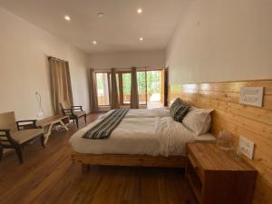 1 dormitorio con 1 cama grande y pared de madera en Sangto Green Guest House, en Leh