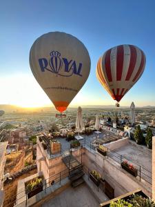 two hot air balloons flying over a city at Dream of Cappadocia in Uchisar