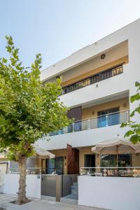 an apartment building with a tree in front of it at Anna Suites in Kos Town