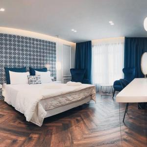 1 dormitorio con 1 cama grande y cortinas azules en BLUE LUXURY SUITES en Preveza