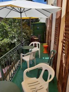 a balcony with tables and chairs and an umbrella at Chez LIZON in Barcelonnette +6 photos
