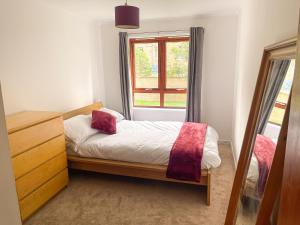 a small bedroom with a bed and a window at Spacious, central and newly decorated apartment in Edinburgh