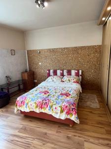 1 dormitorio con 1 cama grande con colcha de flores en U Piekarza za Piecem, en Głuchołazy