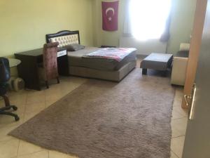 a bedroom with a bed and a desk and a rug at KALECİK OTEL in Kalecik