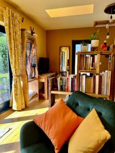 una sala de estar con un sofá verde y libros en The Vikings Retreat en Donington on Bain