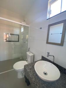 a white bathroom with a sink and a toilet at AP Residêncial Delior - Parada do Jalapão e Aromaterapia in Palmas