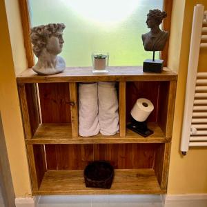 una estantería de madera con toallas y una estatua. en The Vikings Retreat en Donington on Bain