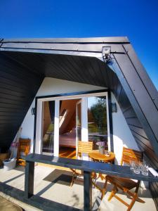 une maison avec une table et des chaises sur une terrasse dans l'établissement Linistea Muntilor Chalet, à Porumbacu de Sus