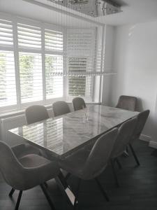a dining room with a table and chairs and windows at 4 bed private home in Colchester in Colchester