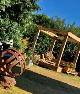 un columpio de madera sentado en el césped en un patio en The Vikings Retreat en Donington on Bain