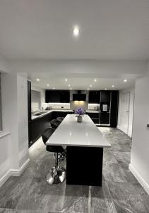a large kitchen with a white island in a room at 4 bed private home in Colchester in Colchester