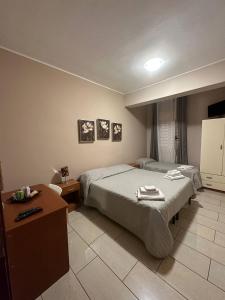 Dieses Hotelzimmer verfügt über ein Bett, einen Schreibtisch und ein Bett der Marke sidx sidx sidx sidx sidx. in der Unterkunft B&B Emmanuel in Reggio di Calabria