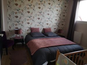 a bedroom with a bed with a floral wallpaper at Le logis du mineur Chez Agnès et Joël in Staffelfelden