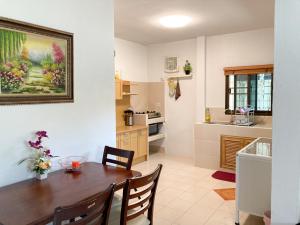 a kitchen with a wooden table and chairs in a room at THAIGO Comfort Stay - Private House in Central Kanchanaburi in Kanchanaburi City