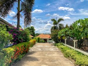 a walkway in front of a house with flowers at THAIGO Comfort Stay - Private House in Central Kanchanaburi in Kanchanaburi City