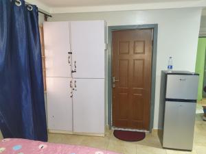 a room with two refrigerators next to a door at Vee female hostel in Wupa