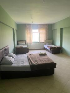 a large room with two beds and a window at KALECİK OTEL in Kalecik