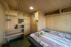 ein Schlafzimmer mit einem Bett in einem winzigen Haus in der Unterkunft Obytný posed Šach in Dačice