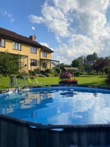 a large plunge pool in a yard with a house at Greenland Apartments in Cēsis