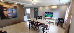 a living room with a table and chairs and a television at Casa quinta Camino al Sol in Junín