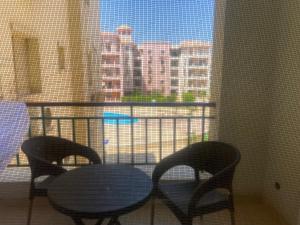 einen Tisch und Stühle auf einem Balkon mit Stadtblick in der Unterkunft A cosy Apartment just for you to relax in Madinat as-Sadis min Uktubar