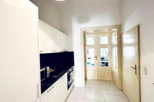 uma cozinha com armários brancos e um forno com placa de fogão em Best Location - Cozy City Centre Apartment em Viena
