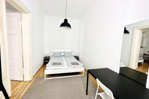 sypialnia z łóżkiem w białym pokoju w obiekcie Best Location - Cozy City Centre Apartment w Wiedniu