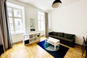 uma sala de estar com um sofá e uma mesa em Best Location - Cozy City Centre Apartment em Viena