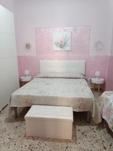 1 dormitorio con 1 cama con pared de color rosa en Holiday home La Rinascita, en Bagheria