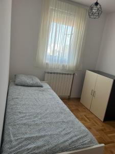 Un dormitorio con una cama grande y una ventana en Apartman JAGODA en Varaždin
