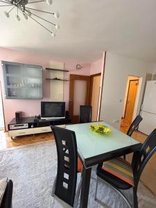 a living room with a table and chairs and a tv at Apartman JAGODA in Varaždin