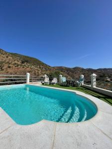 una piscina con tavolo e sedie su un patio di Casa rural Las Casillas a Málaga