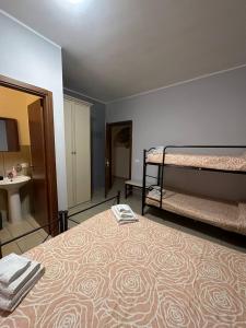 Zimmer mit 2 Betten und einem Waschbecken sowie einem Bad in der Unterkunft B&B Emmanuel in Reggio di Calabria