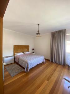 Schlafzimmer mit einem Bett und Holzboden in der Unterkunft Ferrara Rooms in Paços de Ferreira