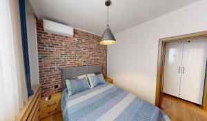 a bedroom with a brick wall and a bed at Апартамент в топ център София 5 Corners in Sofia