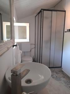 a white bathroom with a toilet and a sink at Casa Davina in Sasca Montană