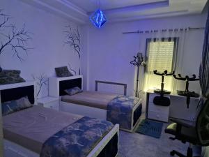 a bedroom with two beds and a window at Appart de Luxe au Centre Urbain Nord in Tunis