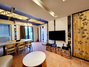 un soggiorno con tavolo e TV a schermo piatto di Annong Image Vacation Home a Sanxing