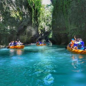a group of people rafting down a river in canoes at Martvili Canyon Room for up to 3 guests in Martvili