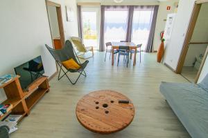 a living room with a wooden table and chairs at Blue Planet São Jorge Azores - RRAL nº 1341 in Velas