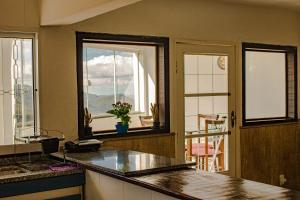 a kitchen with a counter and a view of a balcony at Pouso da Bia in Lavras Novas