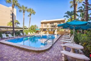 a pool with chairs and umbrellas in a resort at Madeira Vista 601 in St. Pete Beach