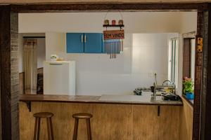 a kitchen with blue cabinets and a white refrigerator at Pouso da Bia in Lavras Novas +40 photos