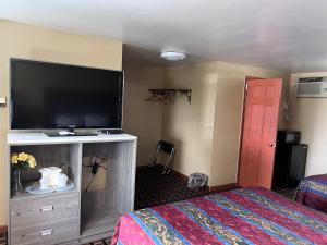 a hotel room with a flat screen tv and a bed at FairBridge Inn Express in Milford