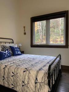 a bedroom with a bed with a large window at Four Season Waterfront Muskoka Retreat in Bracebridge