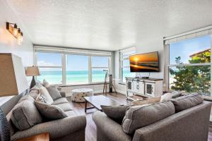 a living room with two couches and a television at Madeira Vista 201 in St Pete Beach