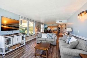 uma sala de estar com 2 sofás e uma televisão de ecrã plano em Madeira Vista 201 em St. Pete Beach