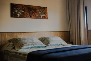 a bed in a bedroom with a picture on the wall at Pouso da Bia in Lavras Novas