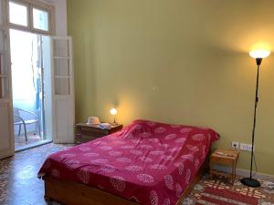 een slaapkamer met een bed met een rode sprei bij An authentic old Jaffa apartment in Tel Aviv